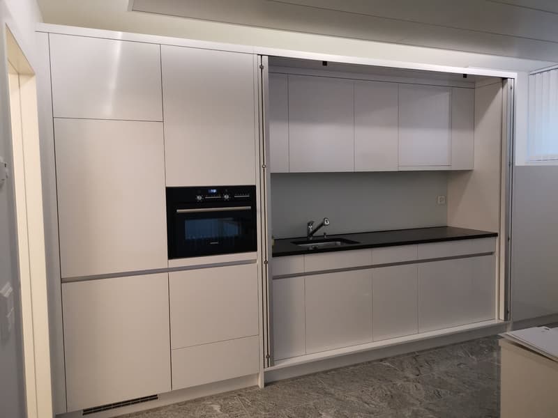 modern kitchen, white cabinets, black countertop, built-in oven and sink