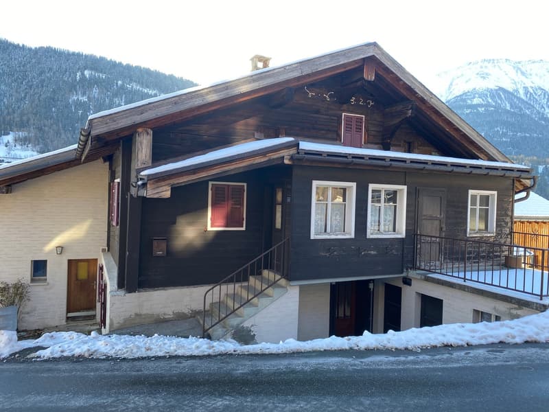 Detached house, wooden and brick facade, steep roof, balcony, ground floor partially raised