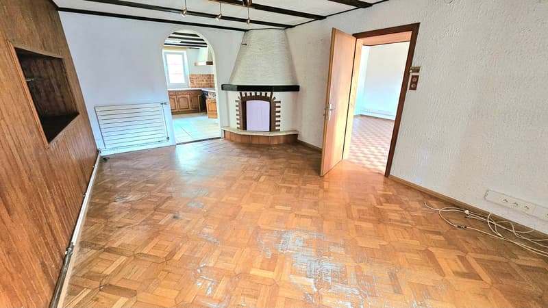 Hardwood floor, white walls, arch entrance, fireplace, archway with window, cabinet