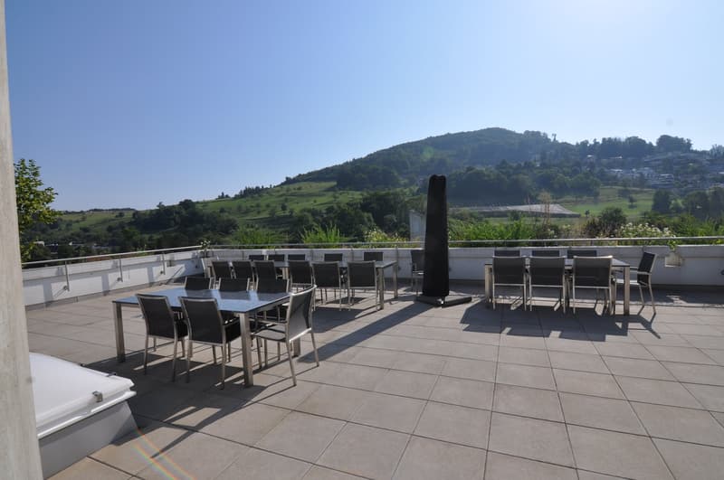 rooftop terrace with dining tables and chairs, closed umbrella, fenced, view of hills