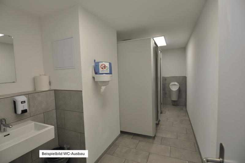 a toilet room with a sink, mirror, and toilet booths