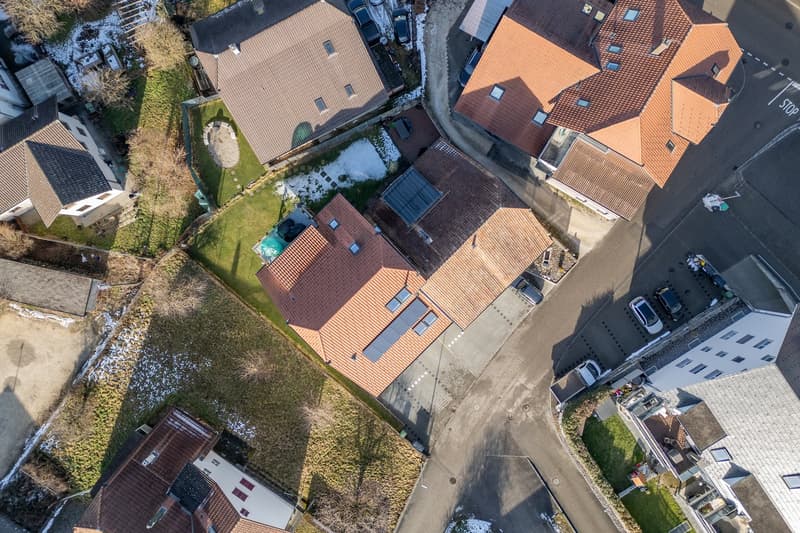 6 houses in a residential neighborhood, one with a brown roof and multiple solar panels