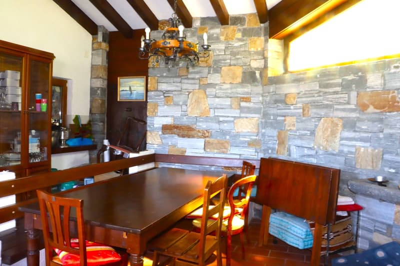 Dining table, wooden chairs, wooden cabinet, dining bench, chandelier, stone wall