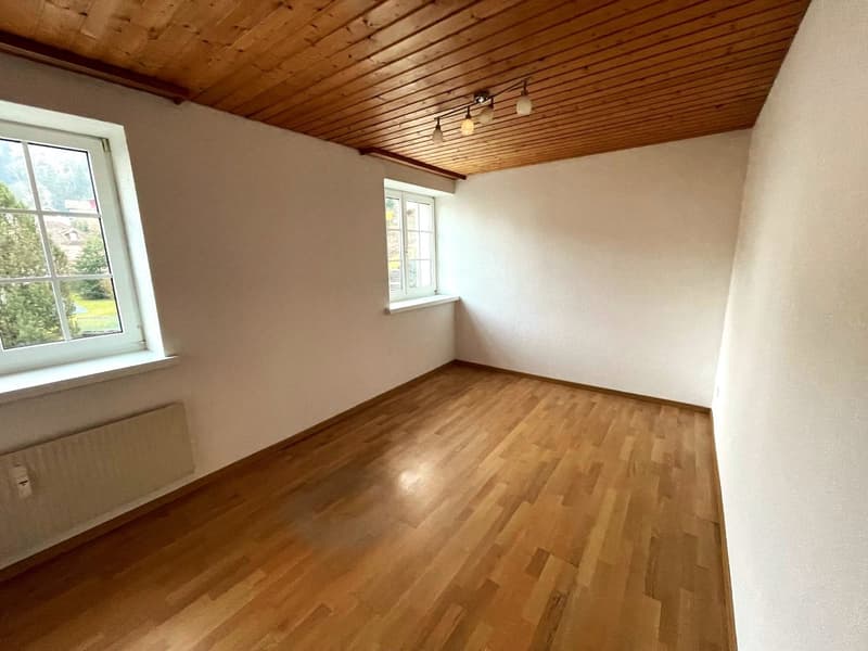 empty room, wooden floor, white walls, wooden ceiling, two windows, radiator