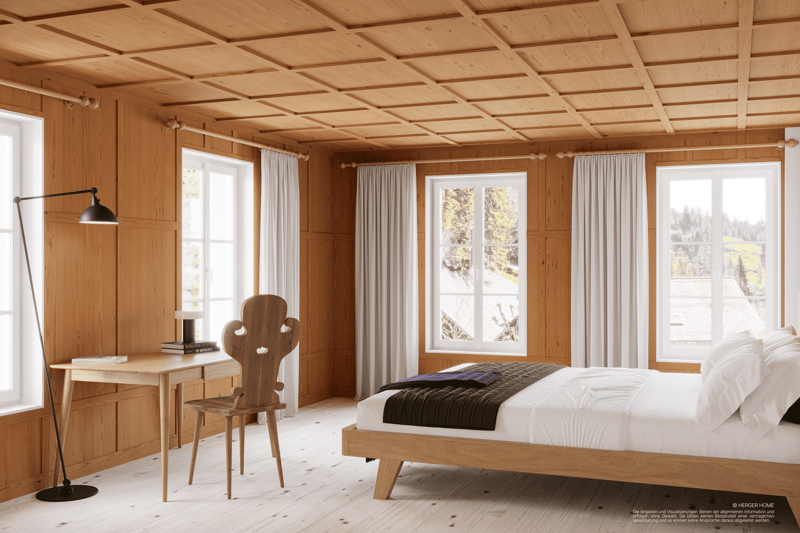 Spacious bedroom with wooden paneled walls and ceiling, large windows providing a scenic view, a wooden bed frame, a wooden desk and chair, and curtains covering the windows.