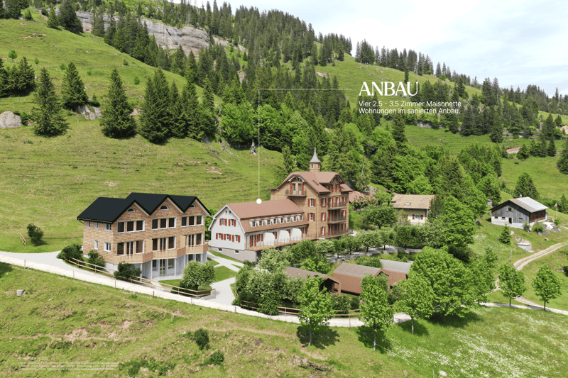 Multiple buildings, located on a hillside, modern buildings surrounded by trees and grass