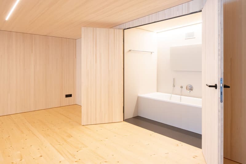 wooden walls, wooden floor, white bathtub, shower, open door