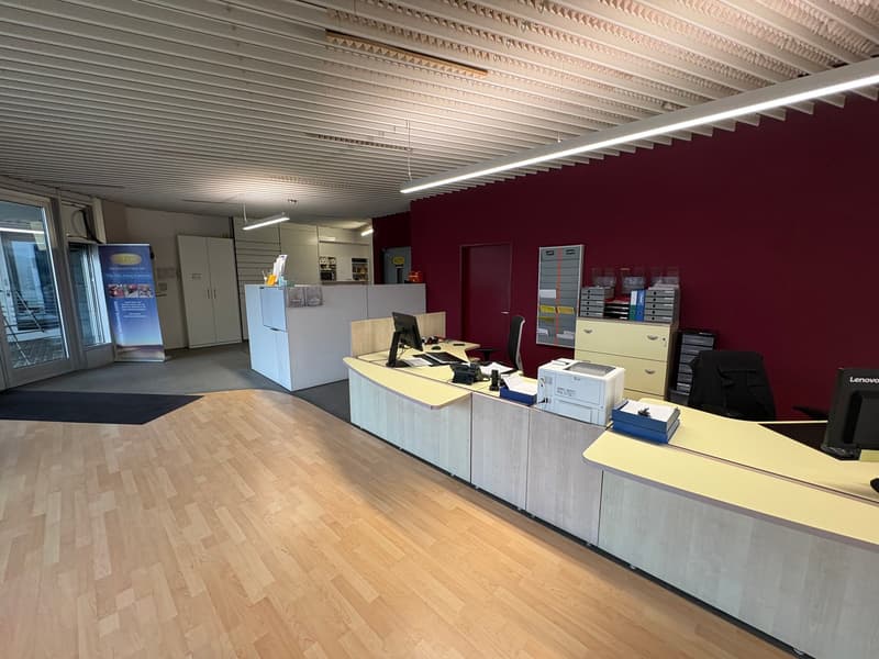 office space with modern furnishings, reception desk, wooden floor, white cabinets, computer monitors, printer