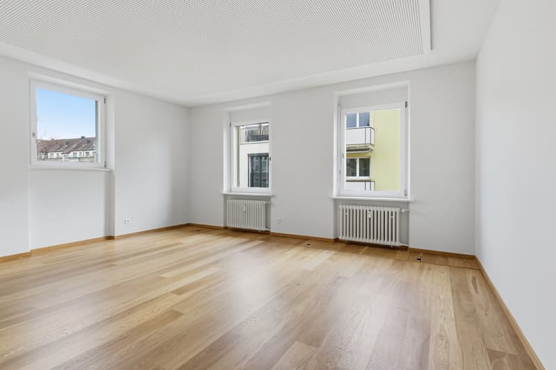 empty room, wooden floor, white walls, two windows, white radiators