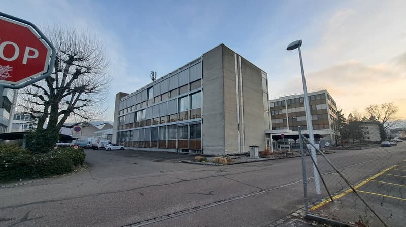 4 story office building, grey color, glass windows, parking lot, trees, street light