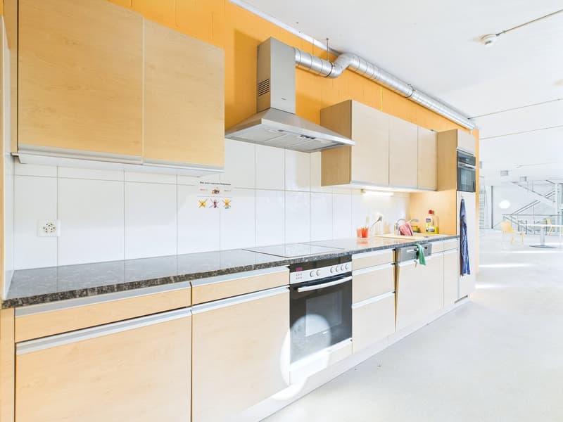 Modern kitchen with white cabinets, granite countertops, built-in oven and dishwasher, and yellow accent walls.