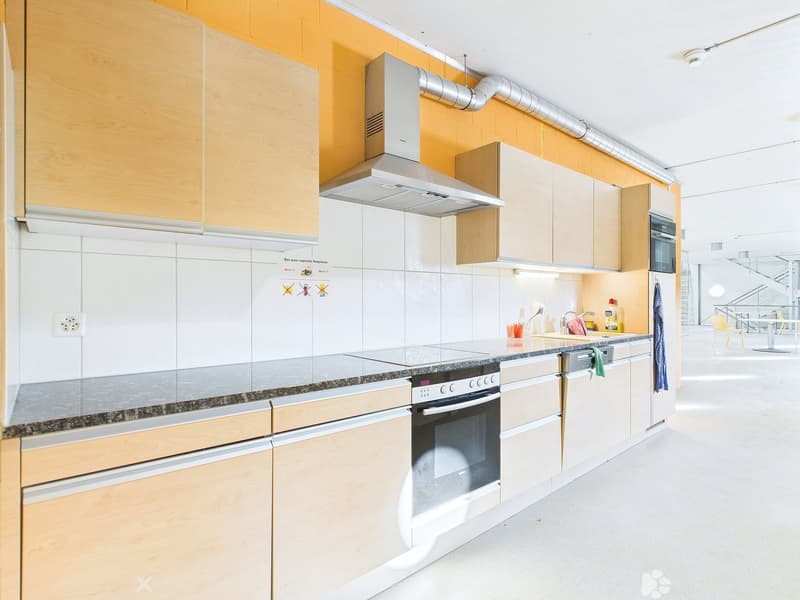 Modern kitchen with white cabinets, granite countertops, built-in oven and stove, dishwasher, and washing machine