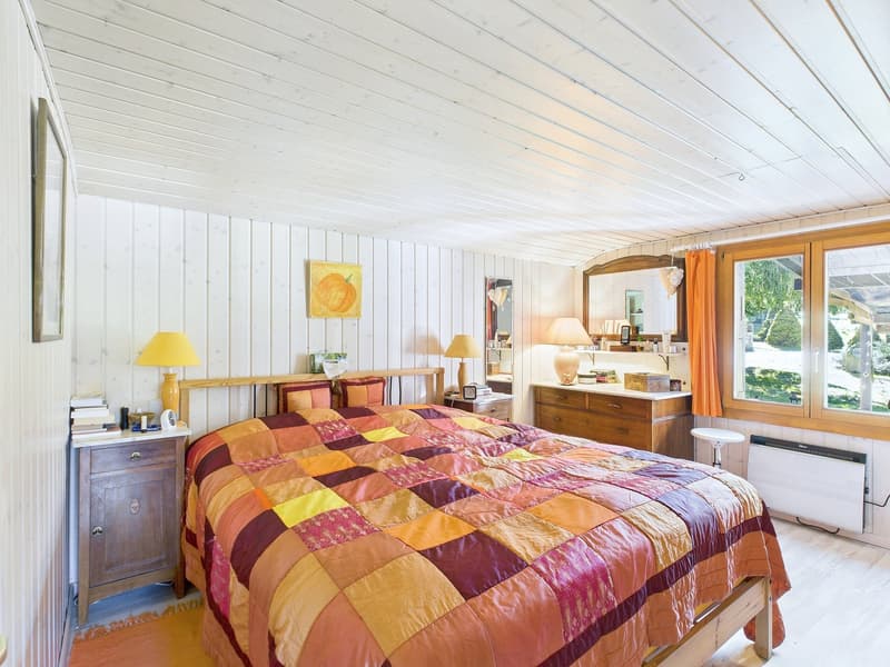 wooden bed, colorful quilt, lamp, nightstands, dresser, mirror, picture frame, heater, books, pillows