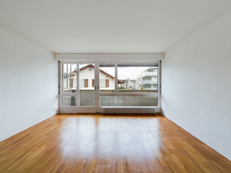 empty room, wooden floor, white walls, large glass doors leading to balcony, white ceiling