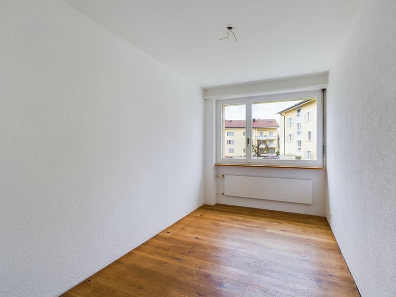 empty room, white walls, wooden floor, large window, white radiator