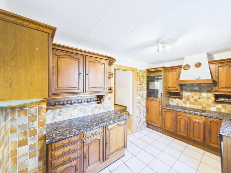 kitchen with wooden cabinets, granite countertops, tiled floor, built-in oven, dishwasher