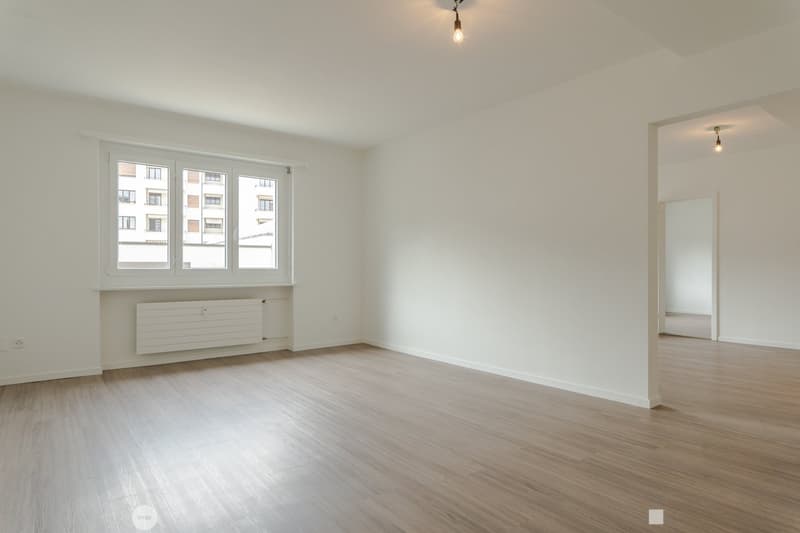 empty room, white walls, wooden floor, large window, radiator