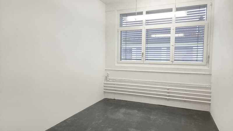 empty room with white walls, grey floor, windows with blinds