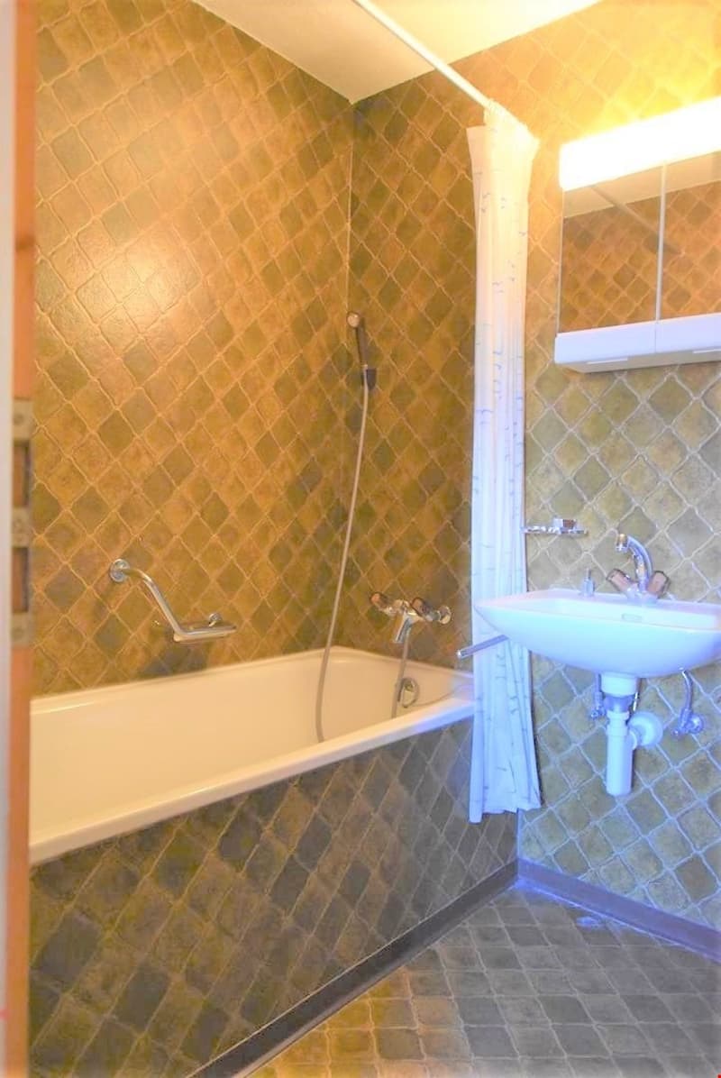 Bathroom with bathtub, shower, sink, and mirror