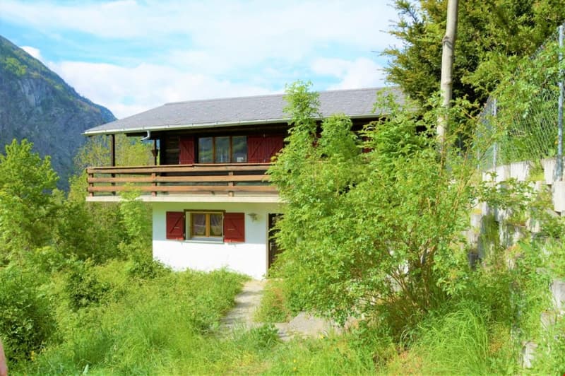 2 story house, wooden exterior, red shutters, balcony, surrounded by trees and grass