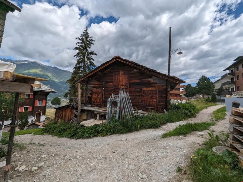 wooden chalet style house, elevated foundation, mountains in background, dirt road, streetlight