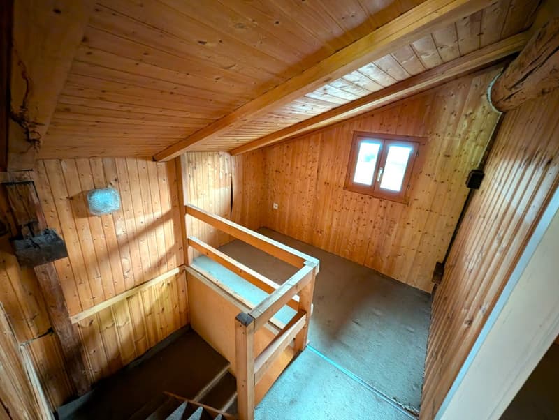room with wooden paneling, small window, wooden stairs