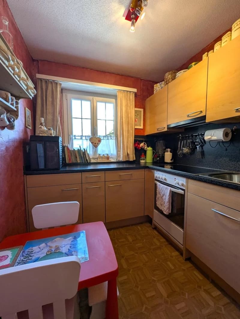 Red and white kitchen, table, chairs, oven, window, cabinets, microwave, coffee machine, roll of tissue, sink