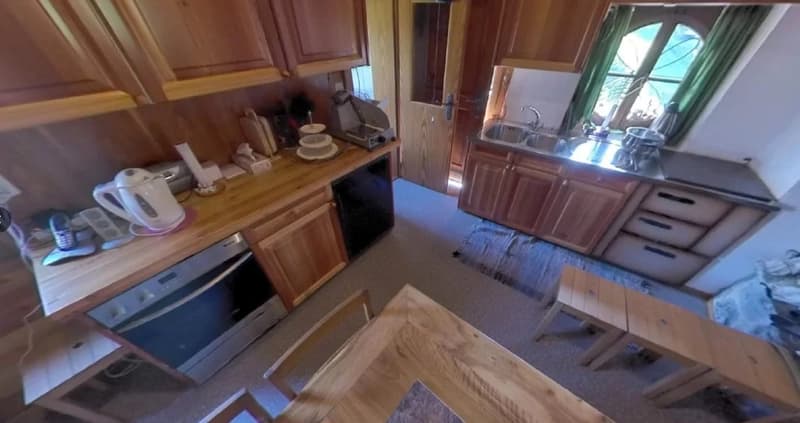 Wooden cabinets, countertop, stove, dishwasher, various kitchen appliances and utensils