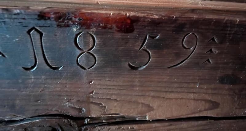 The image shows a wooden surface with the numbers 11859 carved or engraved into it.