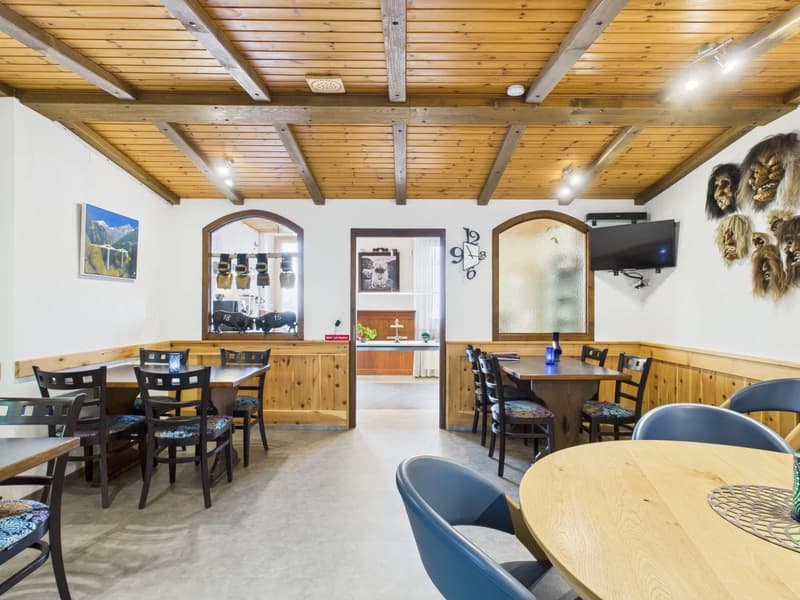 wooden ceiling, wooden wall paneling, tables, chairs, paintings, TV