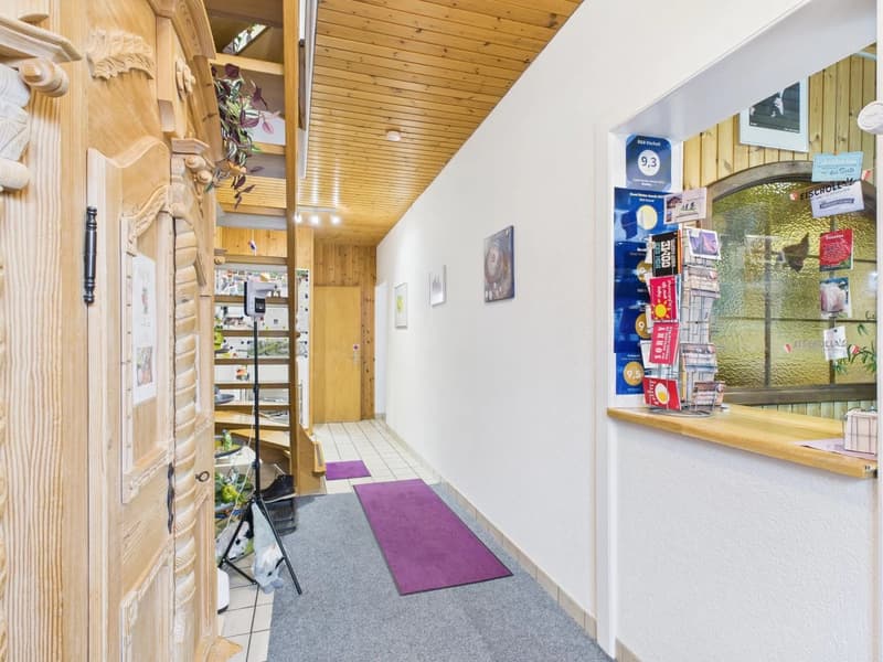 wooden door, tiled floor, purple rugs, wooden beam ceiling, framed pictures on wall