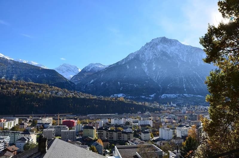 Aerial view of town with buildings, mountains, and clear sky