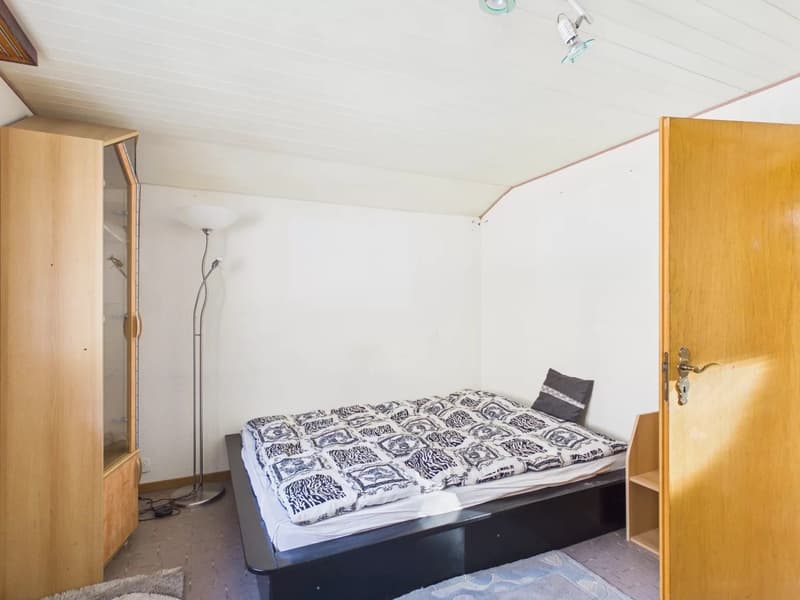 small room, bed, wooden cabinet, floor lamp, shelves, rug, open door