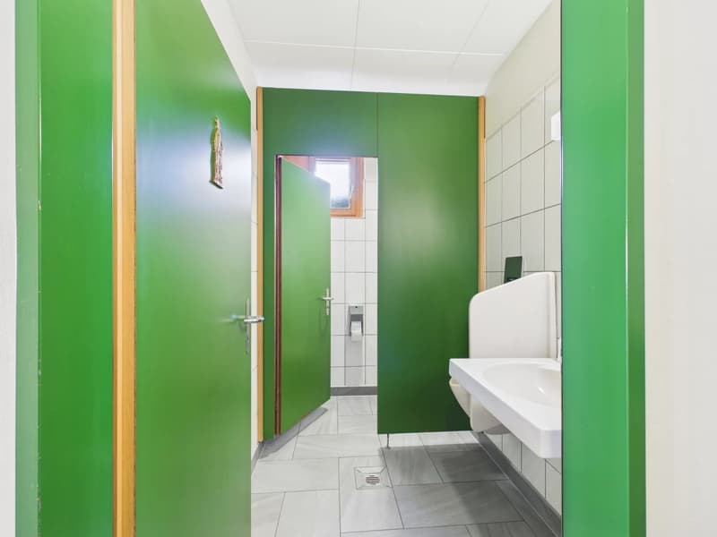 Green doors, white sink, green wall panels, tile floor, white tiles on wall