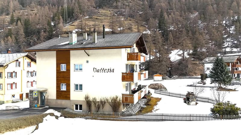 3 story building, white and brown exterior, multiple balconies, snow covered ground