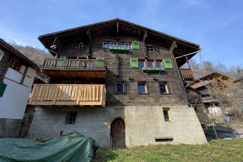 3 story wooden house, green shutters, wooden balconies, concrete ground floor, wooden door