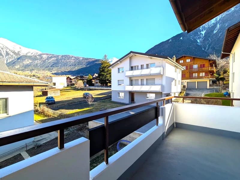 Balcony, mountain view, white exterior, brown roof, fenced yard, cars parked
