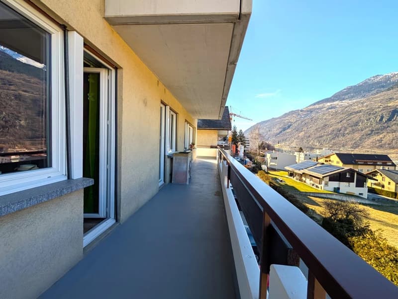balcony with railings, view of mountains, yellow walls, glass windows, trash bin