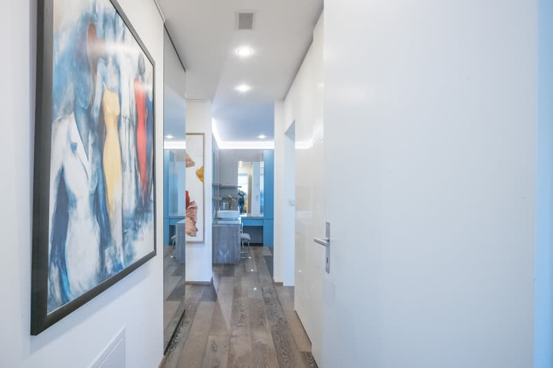 Corridor with hardwood floor, decorative painting, white walls