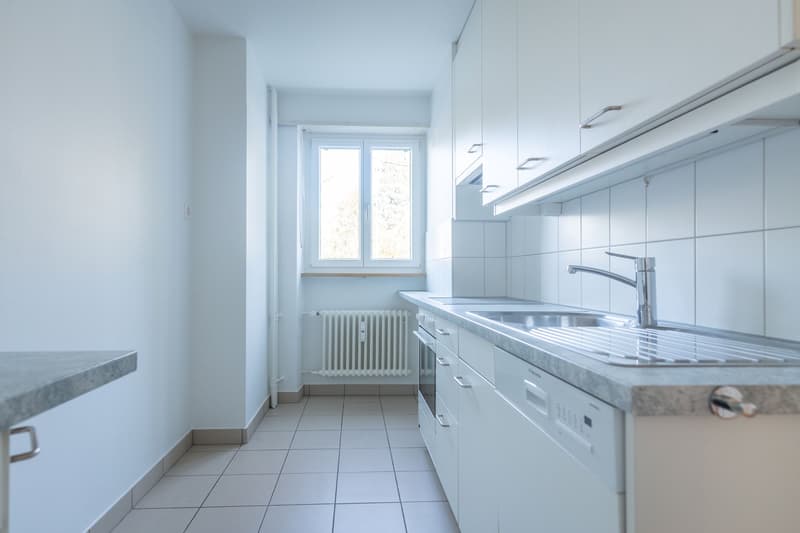 empty kitchen with modern cabinets, marble countertops, dishwasher, stainless steel sink, electric range, underfloor heating