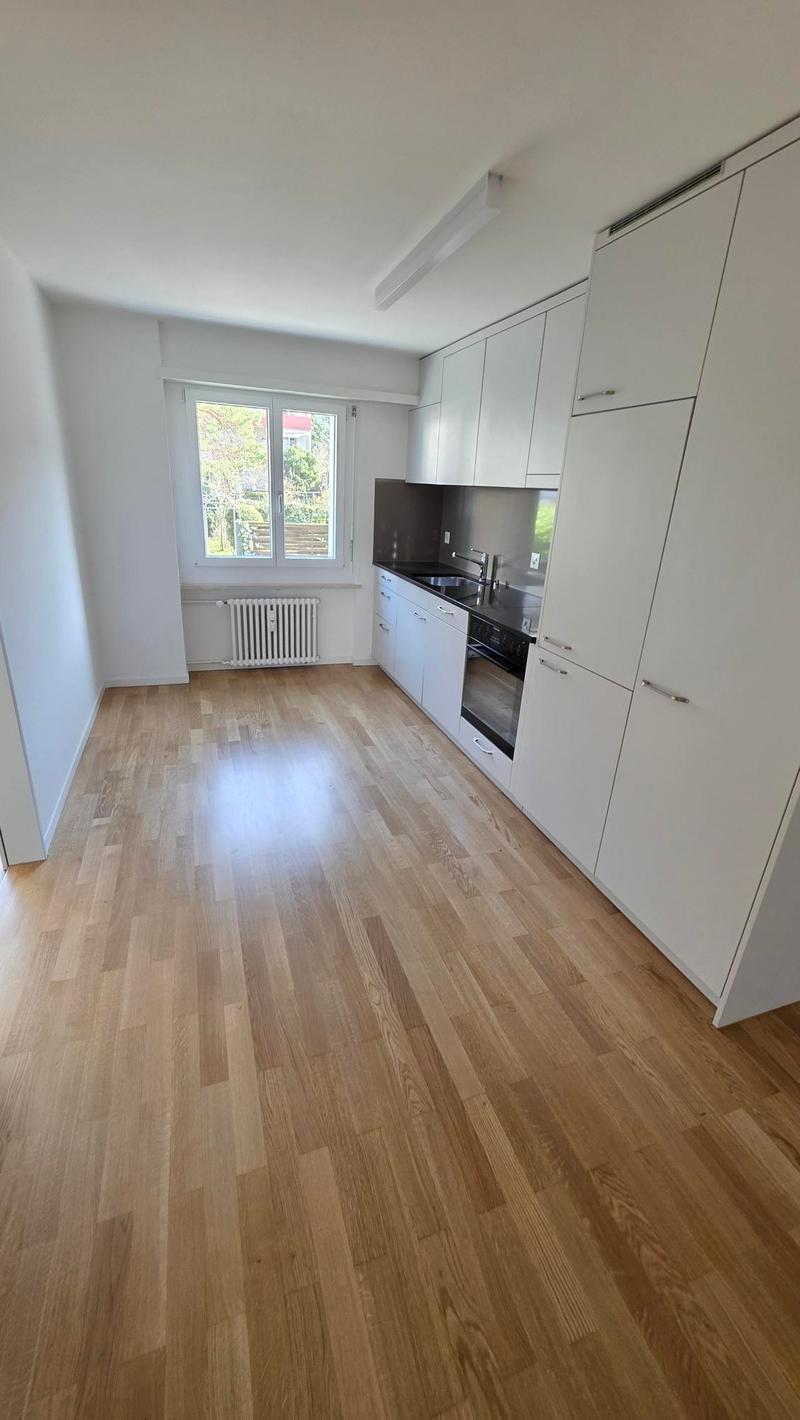 wooden floor, white wall, white kitchen, windows, white radiator, oven, sink, faucet