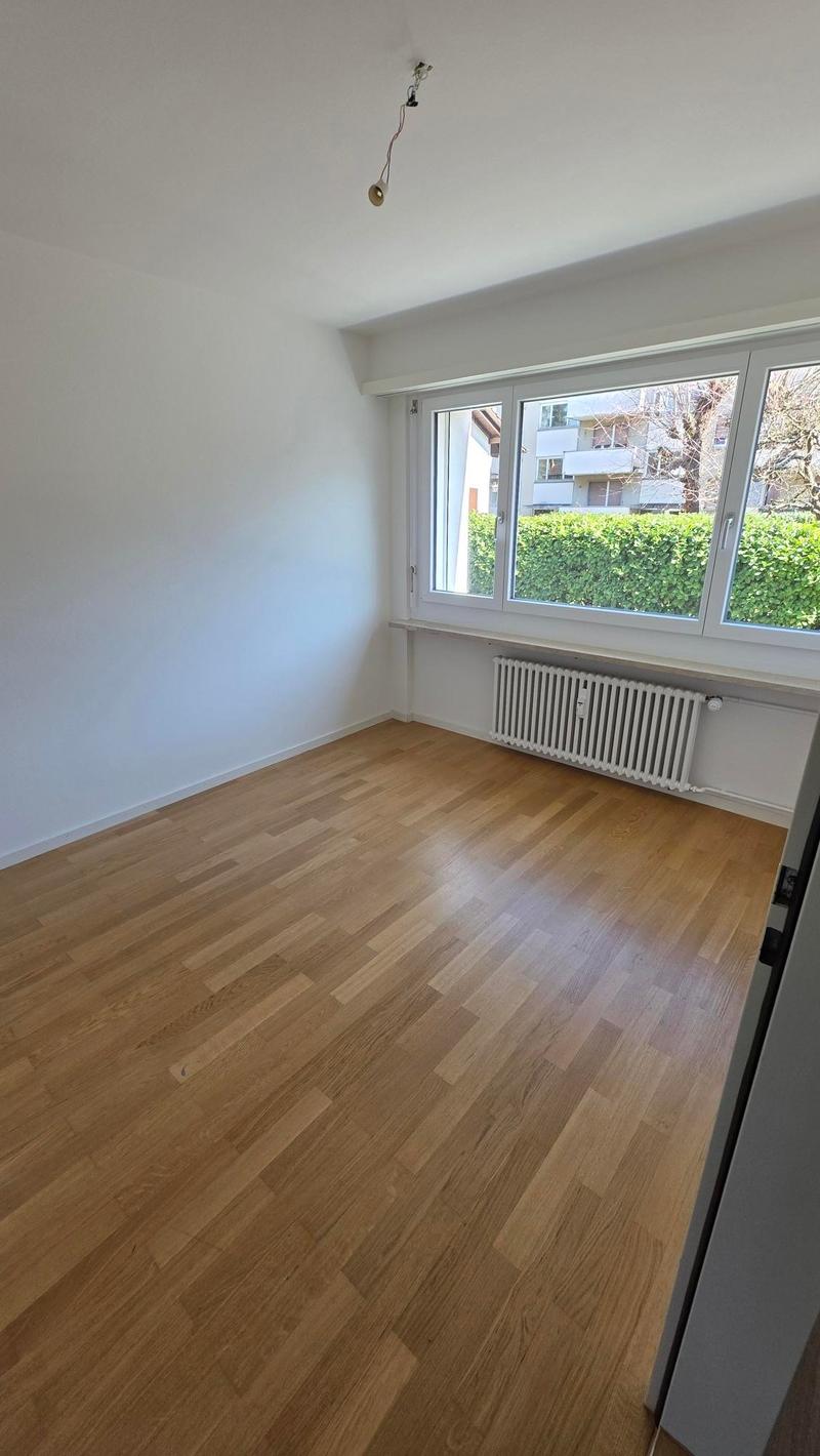 empty room, wooden floor, white walls, windows, radiator