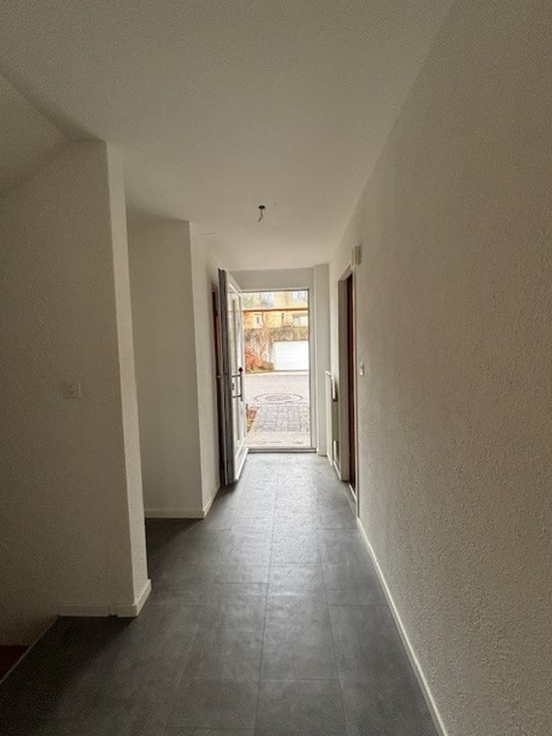 Empty hallway with white walls and tiled floor