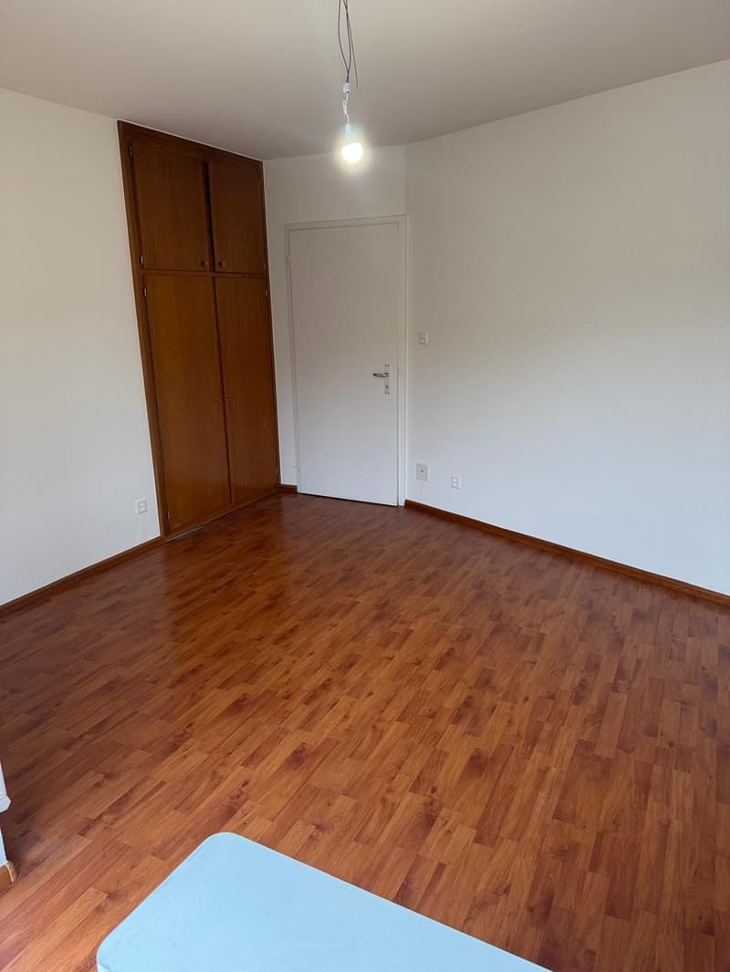 empty room, wooden floor, white walls, wooden cabinet, door, power outlets