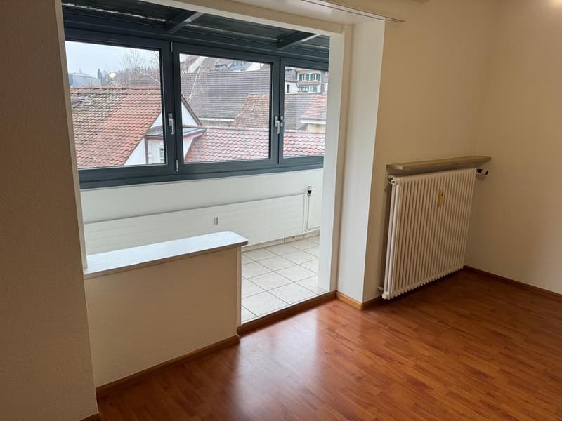 empty room, large window, wooden floor, white walls, radiator