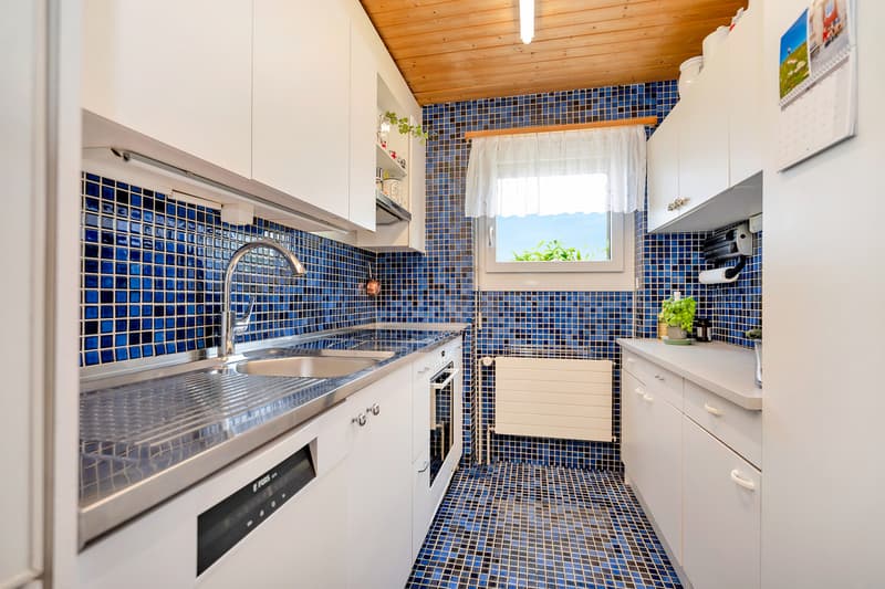 Küche mit Glaskeramikherd, Kühlschrank, Backofen und Geschirrspüler