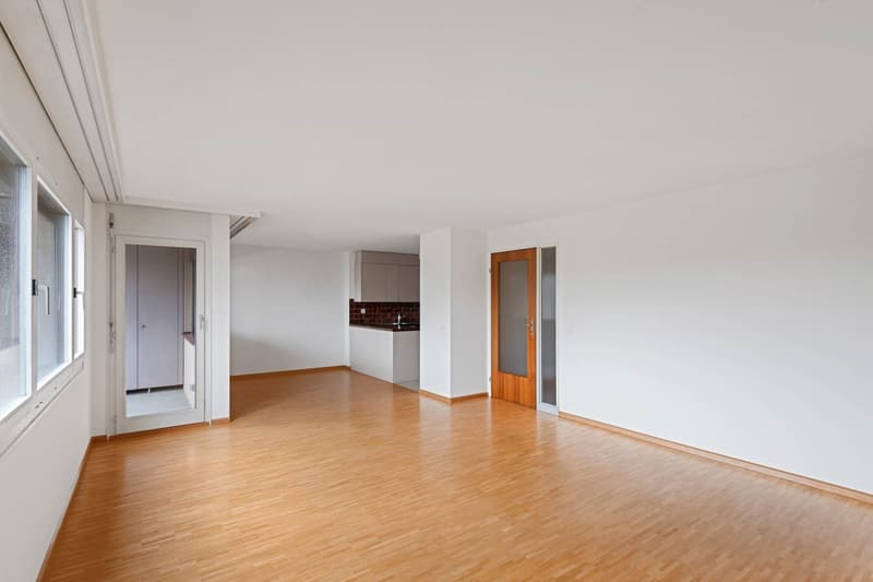 Empty room, wooden floors, white walls, three windows, one door, cupboard