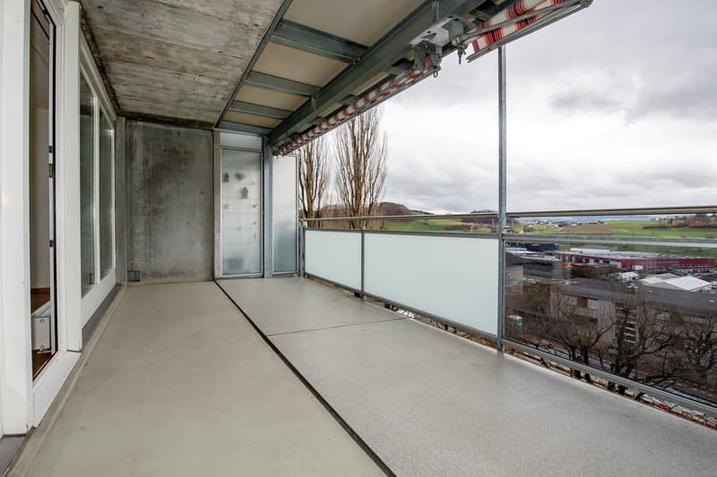 terraced balcony, concrete flooring, glass railing, clear view of a valley and town