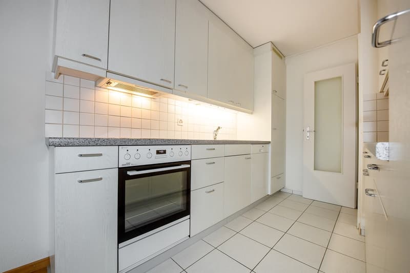 modern kitchen, white cabinets, tile flooring, electric oven, dishwasher, tiled backsplash