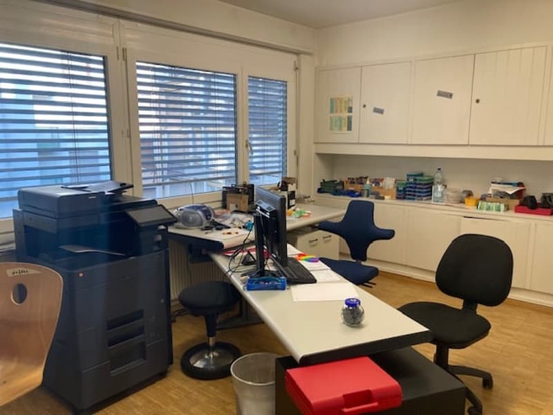 Office with desk, chairs, printer, computer, cabinet, and trash bin.
